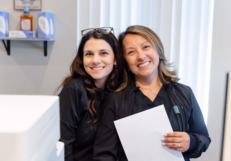Two welcoming team members at The Pampered Tooth front desk.