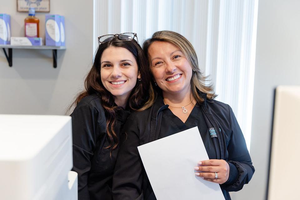 Two smiling team members at The Pampered Tooth.